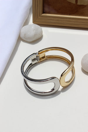 Soft Armour Bracelet on a white surface with a wooden frame and stone in the background