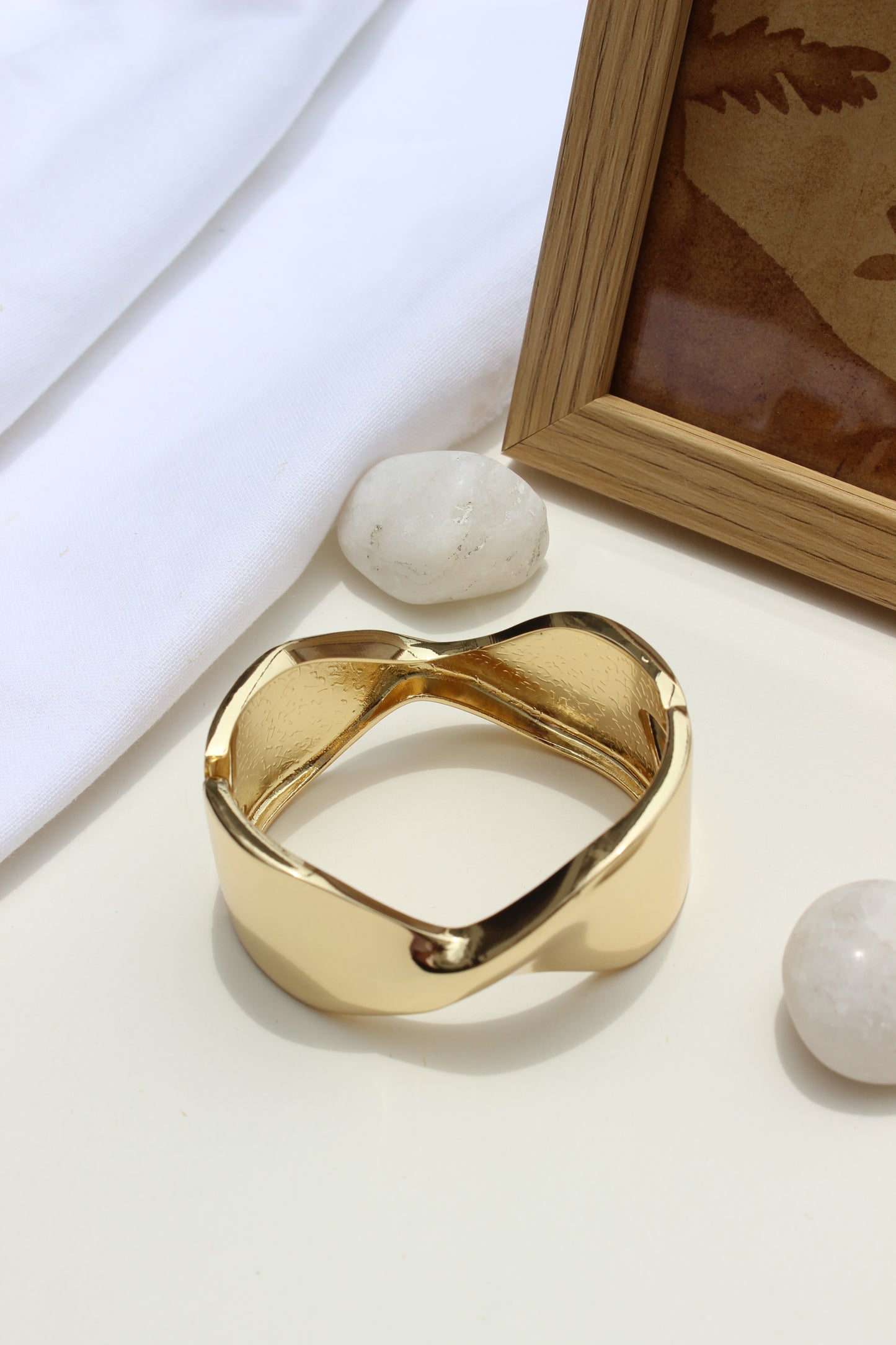 Molten Curve Bracelet on a light surface with a blurred background