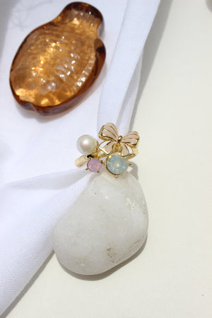 Saltbloom Ring with pearls and gold elements on a white fabric background