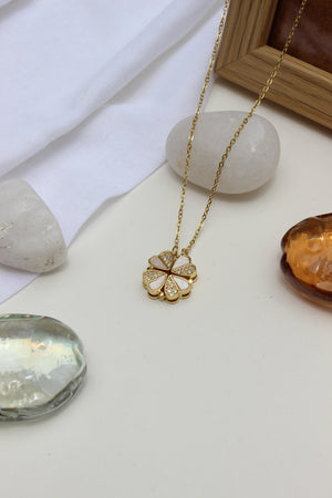 Oyster Petal Pendant Necklace on a white surface with stones and seashell