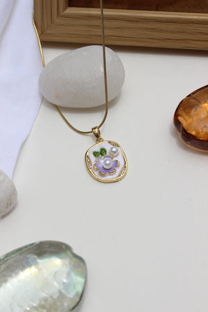 Wildflower pendant necklace with purple floral design on white surface with decorative stones