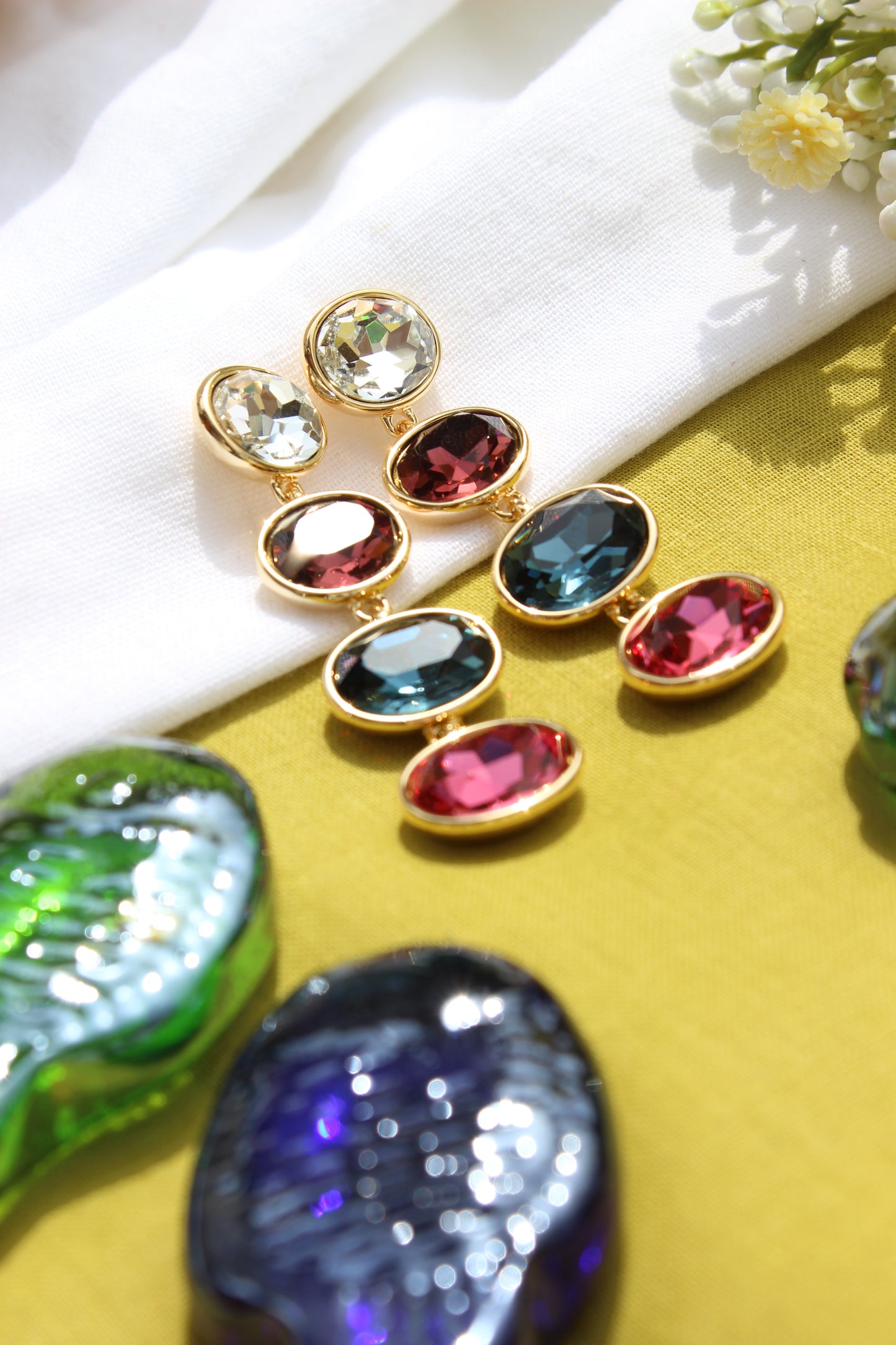 Colorful Aura Drape Earrings on a yellow background