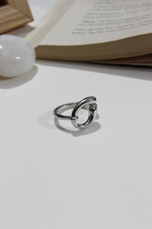 Lunar Trace Ring on a white surface next to a book