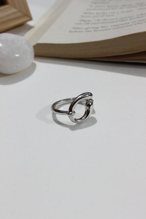 Lunar Trace Ring on a white surface next to a book