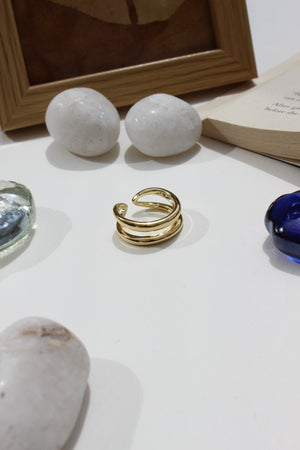 Ember Ring on a white surface with decorative items like stones and a book