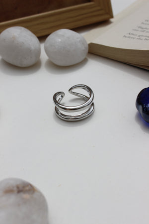 Brushed Moon Ring on a white surface with books and stones in the background