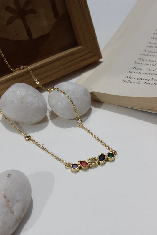 Carry Light Pendant Necklace on a white surface next to an open book