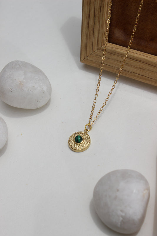 Forest Pulse Pendant Necklace on a white surface with stones