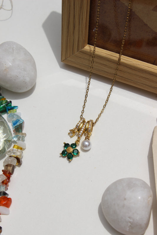 Lustre Garden Charms Pendant Necklace on a white surface with stones