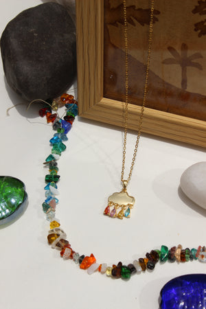 Skydrops Pendant Necklace on a white surface with a wooden frame and stones in the background