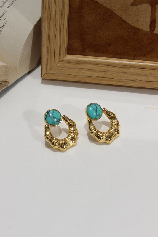Azure Arc Earrings on a white surface next to a wooden frame
