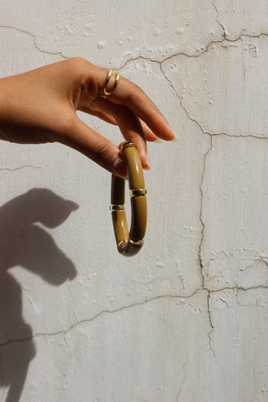 Mocha Toffee Bangle Bracelet on a textured beige surface