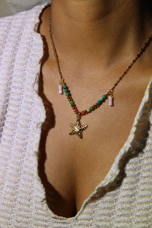 Star of Shore Necklace with beads on a model's neck against a textured beige background