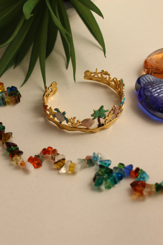 Lagoon Dream Cuff Bracelet on a beige surface with a plant leaf