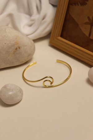 Maree Cuff Bracelet on a neutral background with stones and fabric