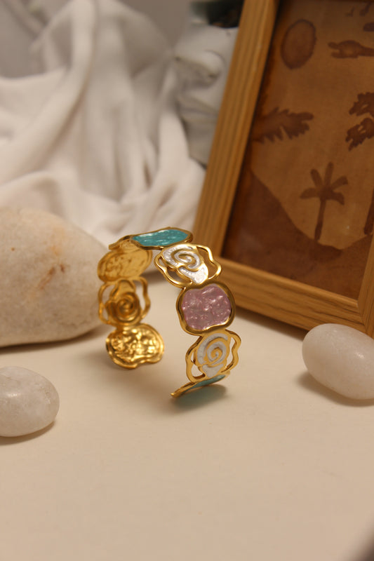 Pearled Blossom Cuff Bracelet on a white surface around decorative stones