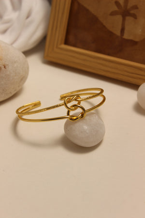 Eterna Knot Cuff Bracelet with a stone on a neutral background