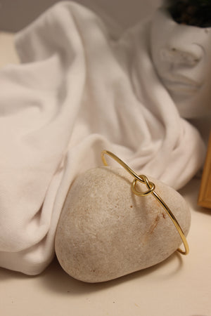 Entwine Cuff Bracelet on a stone held by a white cloth