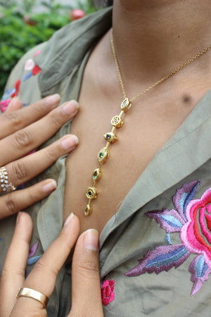 Lustre Pour Necklace on a neck with floral embroidery in the background