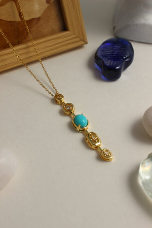 Medina Moon Necklace with a turquoise stone on a light surface