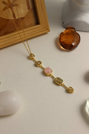 Rosaline Dawn Necklace on a light background with seashell and stones