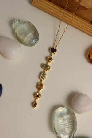 Amour Pour Necklace with gemstones on a light surface