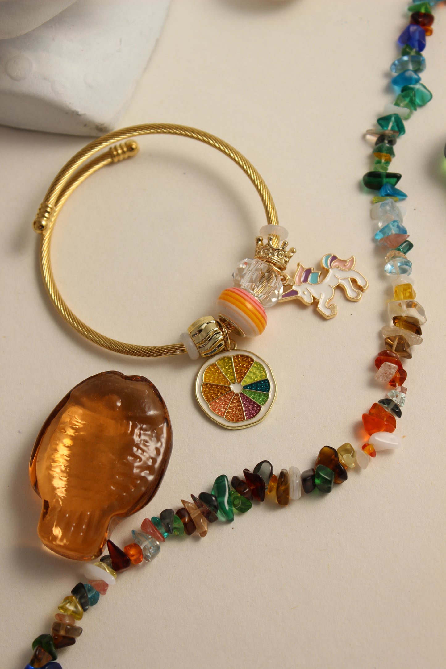 Citrus Carnival Bracelet with colorful beads and decorative charms on a beige surface