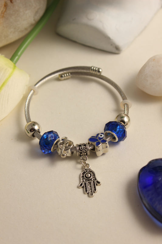 Mystic Iris Bracelet with blue beads and charms on a light surface
