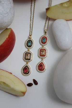 Empress Flame Necklace with gemstones on a surface with apples