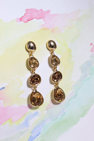 Honeyfall Earrings with brown gemstones on a watercolor background