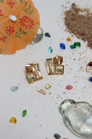 Copper Glow Earrings on a textured surface with seashells