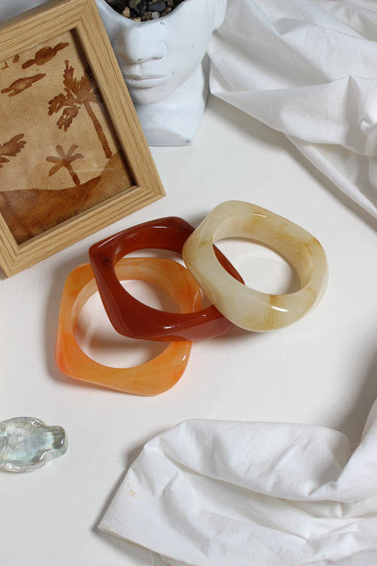Fizz Resin Bangles on a white fabric background