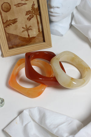 Fizz Resin Bangles on a white surface with a framed artwork
