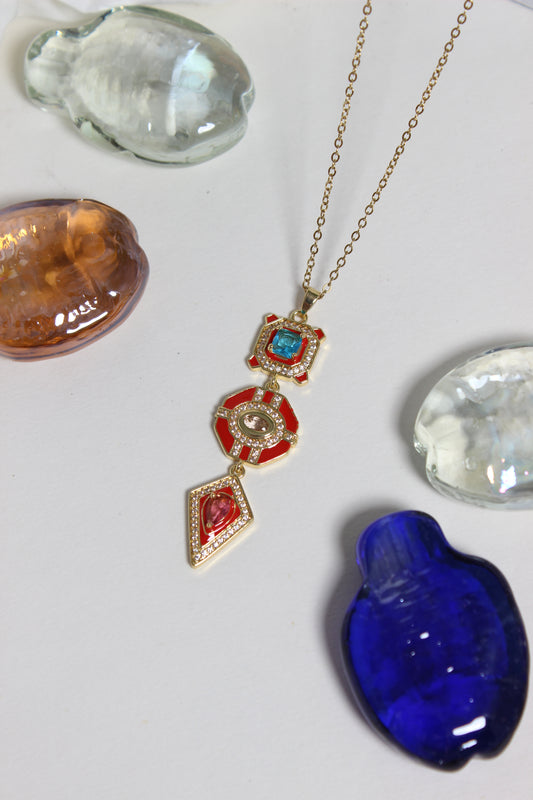 Inferno Charm Necklace on a white surface with colorful stones