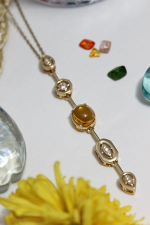 Coralie Necklace on a white surface with flowers