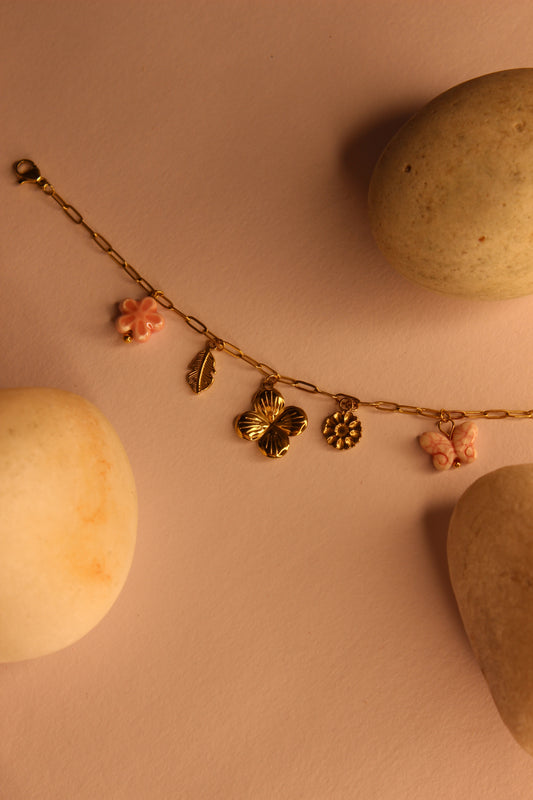 Flutter Bloom Charms Bracelet on a pink surface with stones