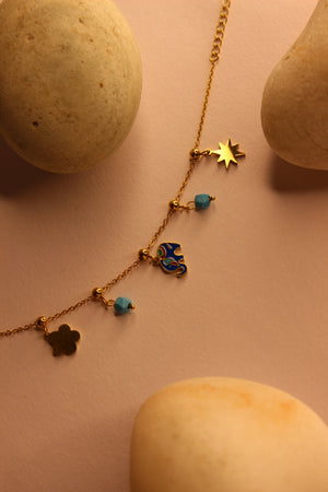 Elegant Wishkeeper Charms Bracelet displayed with stones on yellow surface, customizable and stylish bracelet