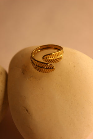 Adara Ring on a beige surface with a blurred background