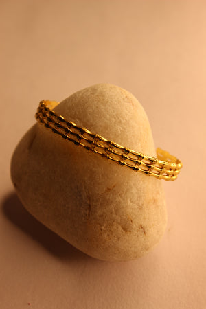 Meira Cuff Bracelet on a stone with a beige background