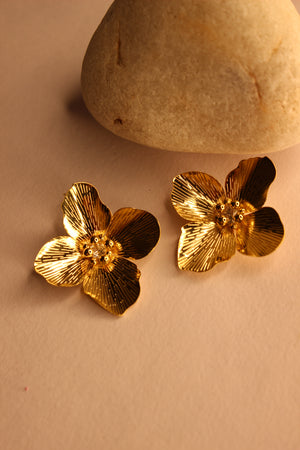 Pollene Earrings on a beige surface