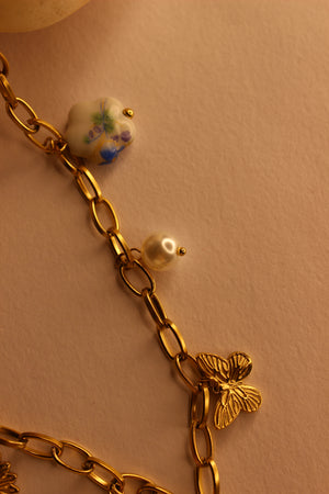 Hearts in Bloom Charms Necklace with decorative stones on a beige background