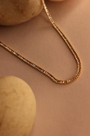 Twilite Necklace on a beige background with stones