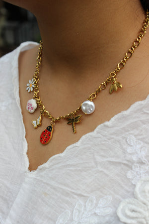 Bloom Folk Charms Necklace on a model's neck against a white lace background