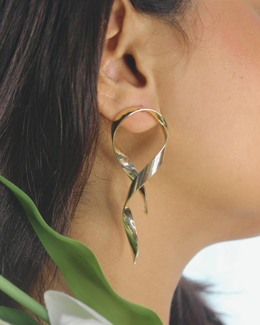 Selene Wave Earrings worn by a model with a blurred background