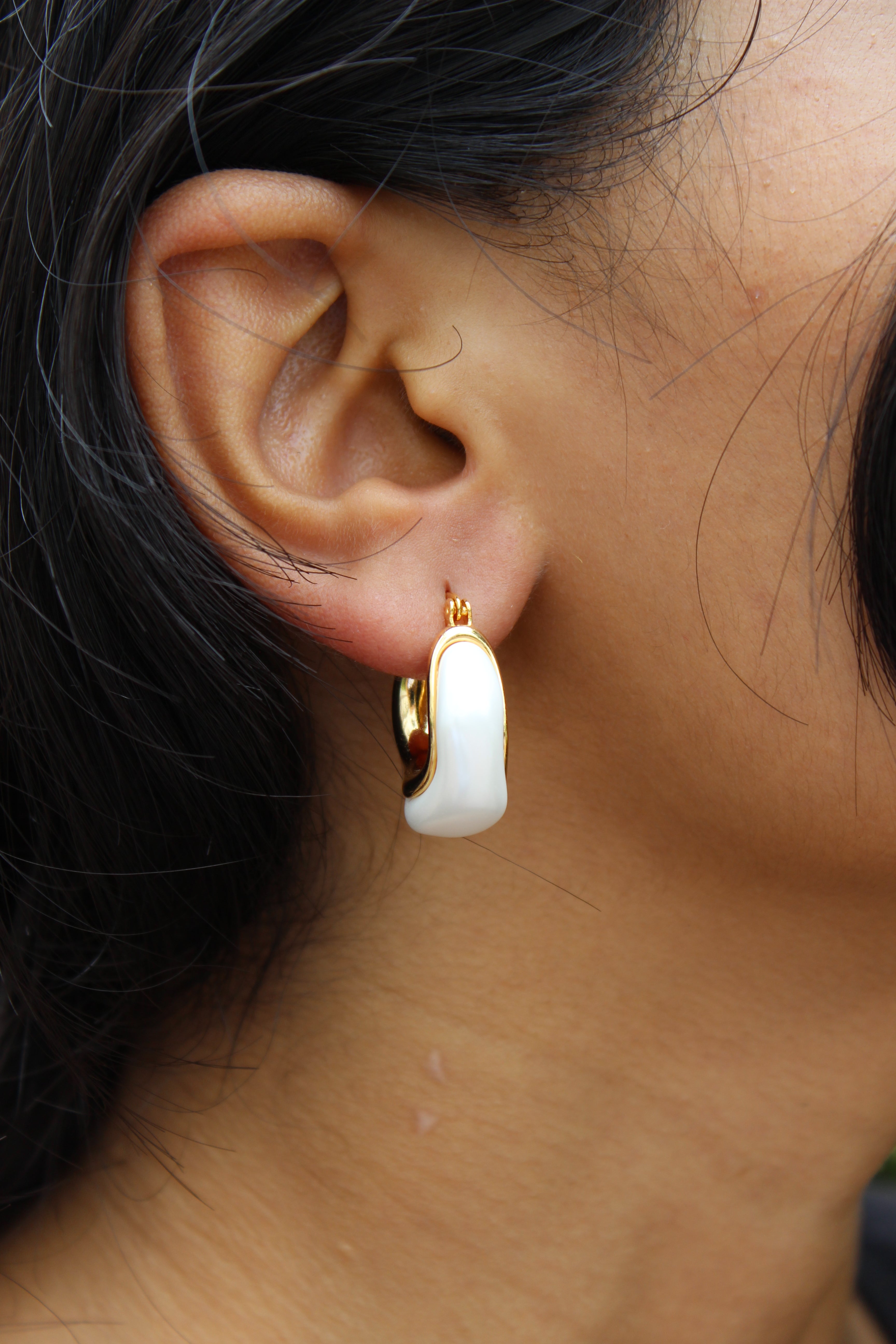 Mira Pearl Hoop Earrings on model's ear with blurred background 