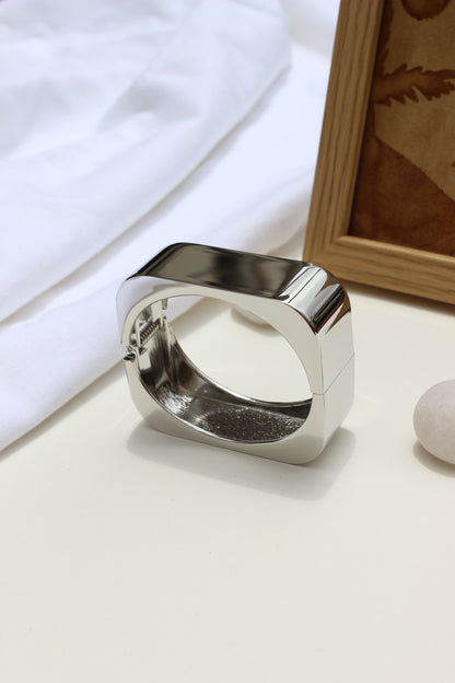 Lucid Hour Bracelet on a white surface with a wooden frame in the background