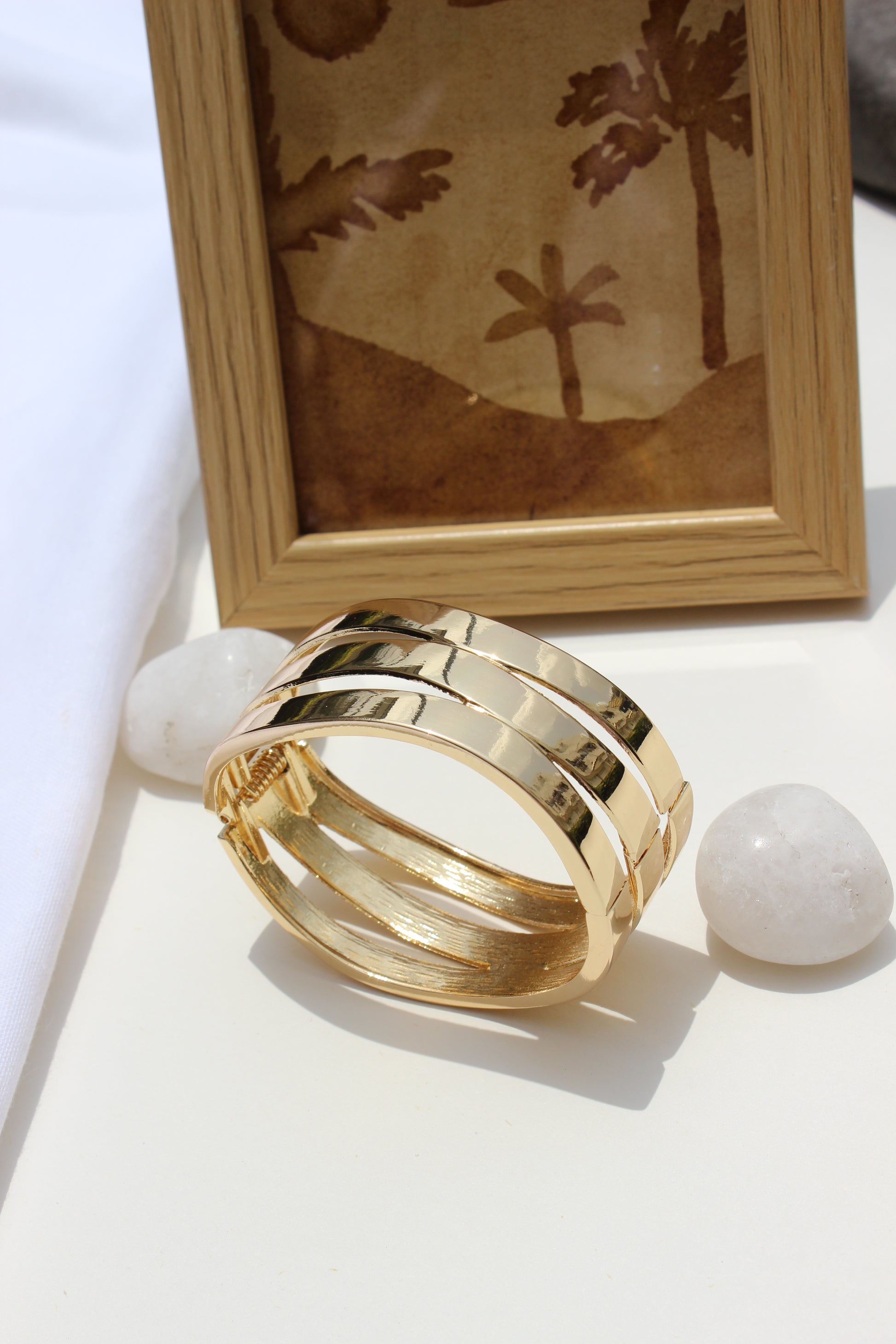 Tide Warp Bracelet on a white surface with a wooden frame in the background