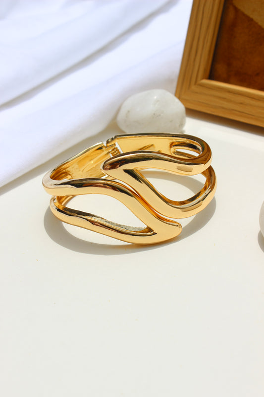 Heavy Petal Bracelet on a white surface with a wooden frame in the background