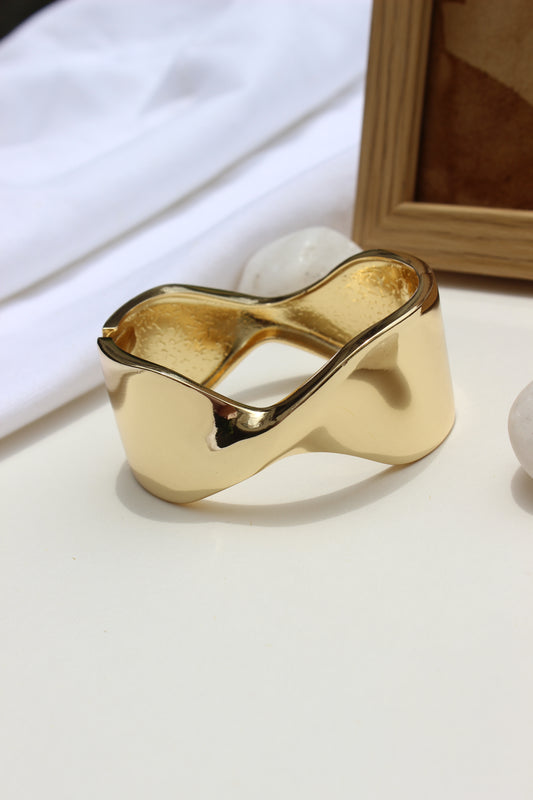 Molten Curve Bracelet on a white surface with a blurred background