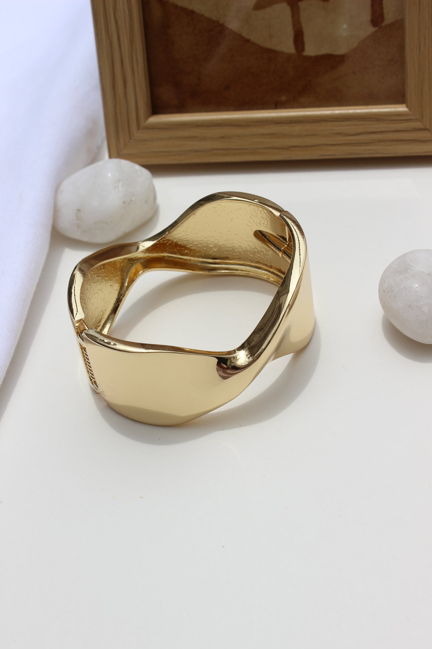 Molten Curve Bracelet on a white surface with a blurred background